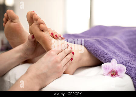 Femme ayant un traitement de pédicure dans un spa ou salon de beauté avec les pieds massage pédicure. Banque D'Images