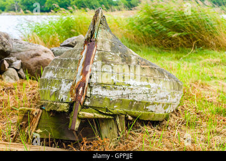 Très vieux bateau pourri couché sur la terre sèche de dépérir. La nature est lentement la matière dans la récupération de navire abandonné. Banque D'Images