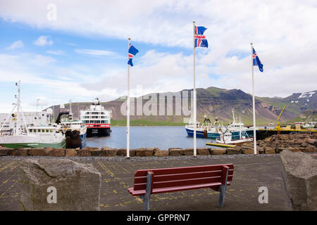 Drapeaux islandais sur le quai avec des bateaux de pêche et un navire de croisière amarré dans le port. Grundarfjordur Islande Snæfellsnes Banque D'Images
