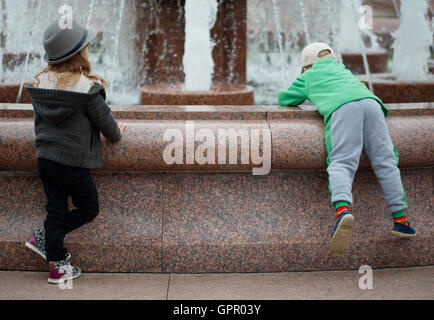 Deux enfants jouant sur la fontaine Banque D'Images