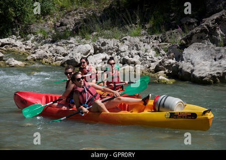 Le tourisme, le sport à l'eau. Quatre jeunes filles s'amusant, jouer sur dans le courant rapide du canot sur les eaux de la rivière Drôme. Vacances d'été en France. Banque D'Images