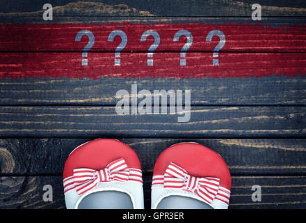 Message d'interrogation et enfants chaussures sur plancher en bois Banque D'Images
