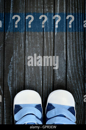 Message d'interrogation et enfants chaussures sur plancher en bois Banque D'Images