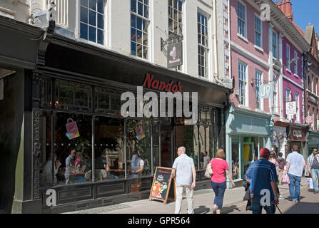 Personnes touristes visiteurs marchant par le restaurant de Nando en été York North Yorkshire Angleterre Royaume-Uni GB Grande-Bretagne Banque D'Images