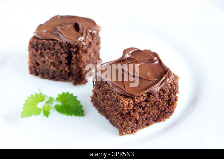 Minis gâteaux au chocolat avec glaçage au chocolat et menthe sur plaque blanche close up Banque D'Images