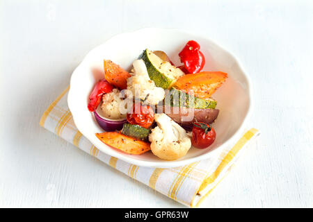 Légumes au four rustique avec des épices et herbes dans un bol blanc close up, repas d'automne bio végétarienne Banque D'Images