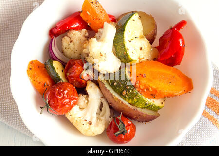 Légumes au four rustique avec des épices et herbes dans un bol blanc close up, repas d'automne bio végétarienne Banque D'Images