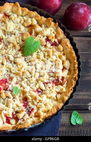 Pâte brisée maison gâteau aux prunes crumble avec sur fond de bois close up Banque D'Images