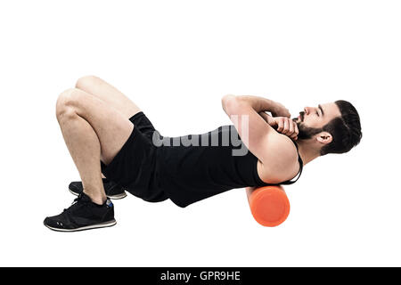 Les muscles du haut du dos massage sportif avec rouleau en mousse. La pleine longueur du corps portrait isolé sur fond blanc studio. Banque D'Images