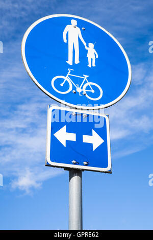 Lane pour vélos et piétons. Panneau routier rond bleu sur fond de ciel bleu nuageux Banque D'Images