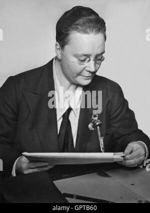 Dorothy Sayers (1893-1957), le célèbre écrivain anglais souvent considéré comme l'un des auteurs britanniques officieusement connu comme 'l'Inklings' (en raison de son amitié avec C.S. Lewis et Charles Williams), l'ouverture d'un paquet à son bureau. Banque D'Images