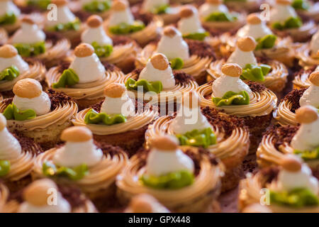 Rangées de petits gâteaux décorés. Banque D'Images