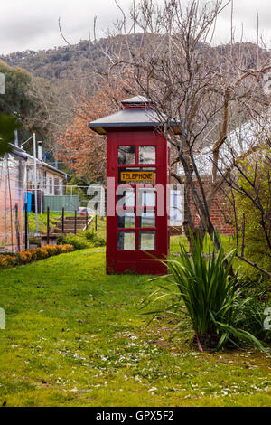 Une vieille cabine téléphonique rouge style dans un chemin de campagne Banque D'Images