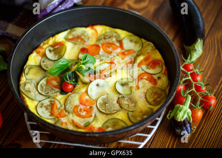 Omelette au plat avec les aubergines et les tomates Banque D'Images