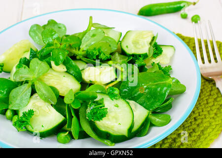 Avec salade de concombre, le pourpier et les pois verts sur les disques sombres Banque D'Images