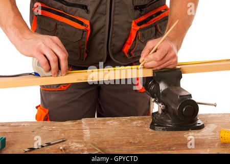 Un menuisier mesure d'une planche en bois dans un atelier isolated over white Banque D'Images