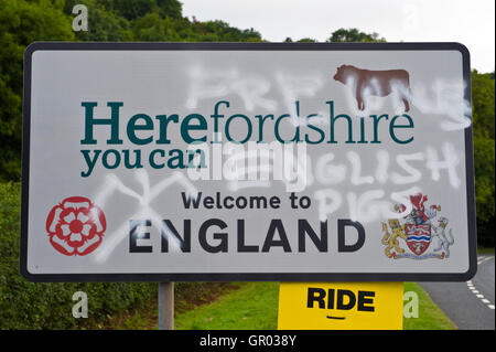 Une vague de graffitis anti-anglais est apparu sur la signalisation routière près de Hay-on-Wye au Pays de Galles sur la frontière de l'Angleterre. Herefordshire Bienvenue en Angleterre Pays de Galles de porcs Anglais Banque D'Images