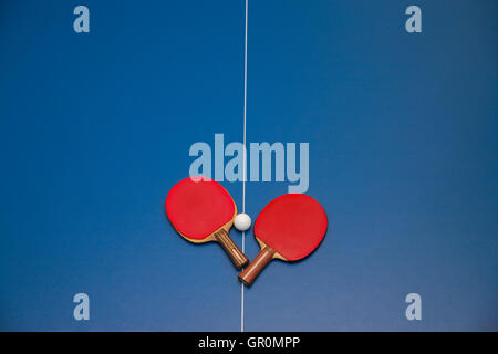 Pour raquettes de tennis de table de couleur rouge et d'une balle sur une table de ping-pong, vue de dessus Banque D'Images