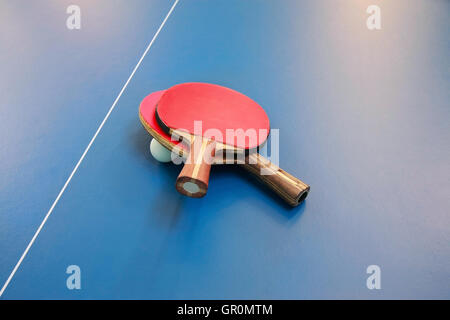 Pour raquettes de tennis de table de couleur rouge et d'une balle sur une table de ping-pong, vue de dessus Banque D'Images