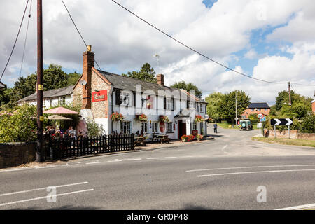 La Couronne, une maison, à peu de Walden, Essex, Royaume-Uni. Les clients à l'extérieur, au soleil d'écouter de la musique live Banque D'Images