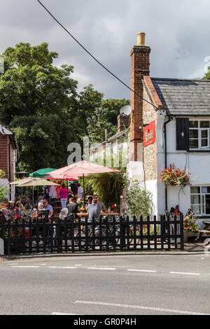 La Couronne, une maison, à peu de Walden, Essex, Royaume-Uni. Les clients à l'extérieur, au soleil d'écouter de la musique live Banque D'Images