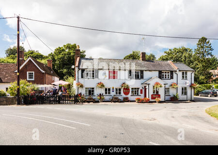 La Couronne, une maison, à peu de Walden, Essex, Royaume-Uni. Les clients à l'extérieur, au soleil d'écouter de la musique live Banque D'Images