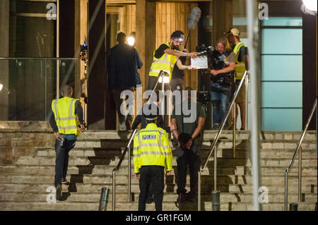 West Bay, Dorset, UK - 6 septembre 2016 - David Tennant et Sir Lenny Henry tournage scène d'arrestation sur les marches de la station de police de nuit pour la série 3 de la série à succès d'ITV Broadchurch. Ed Burnet, le personnage joué par Sir Lenny Henry est considéré d'être placés en détention en menottes par DI Alec Hardy joué par David Tennant, après qu'il avait agressé l'un de l'affiche les caractères Jim Atwood. Photo : Graham Hunt/Alamy Live News Banque D'Images