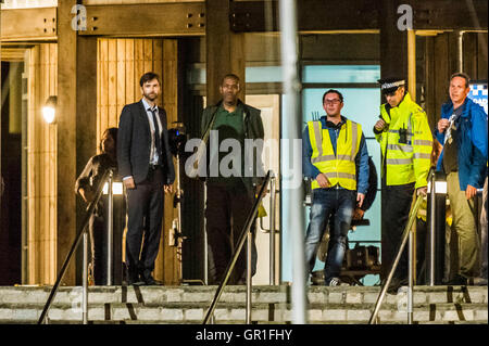 West Bay, Dorset, UK - 6 septembre 2016 - David Tennant et Sir Lenny Henry tournage scène d'arrestation sur les marches de la station de police de nuit pour la série 3 de la série à succès d'ITV Broadchurch. Ed Burnet, le personnage joué par Sir Lenny Henry est considéré d'être placés en détention en menottes par DI Alec Hardy joué par David Tennant, après qu'il avait agressé l'un de l'affiche les caractères Jim Atwood. Photo : Graham Hunt/Alamy Live News Banque D'Images