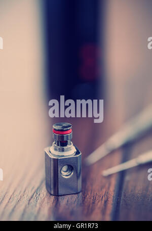 Pour les pièces de mise à jour de vaporisateurs modernes boxmod e-CIG, pièce de rechange avec clapton kanthal. goutte à goutte de la bobine Appareil moderne et modèle clearomizer de microbobines. Une bonne façon d'arrêter de fumer la cigarette la nicotine et d'améliorer la santé. Macro close up Banque D'Images