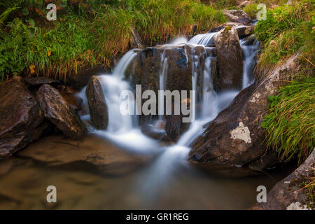 Belle cascade dans les montagnes avec de l'eau mousseuse blanche Banque D'Images