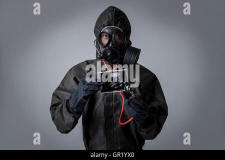 Portrait d'homme portant un masque à gaz et des vêtements protecteurs holding sonogram Banque D'Images