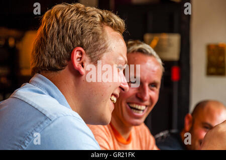 Les conversations de la famille autour de la Table de dîner dans un pub de Village, Sussex, UK Banque D'Images