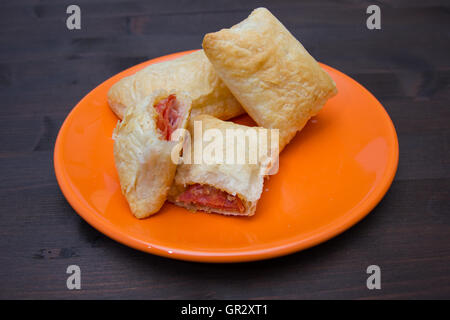 Apéritifs feuilletés au salami et fromage sur une table en bois Banque D'Images