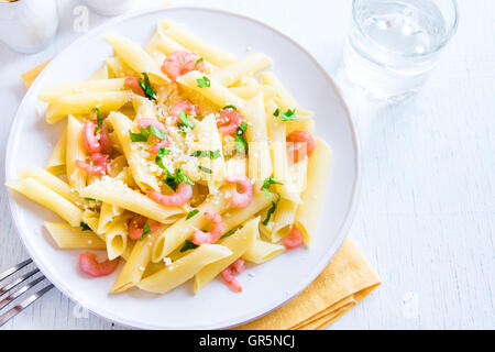 Pâtes penne aux crevettes et parmesan râpé sur fond blanc Banque D'Images