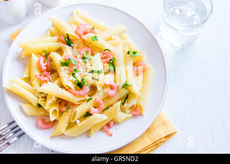 Pâtes penne aux crevettes et parmesan râpé sur fond blanc Banque D'Images