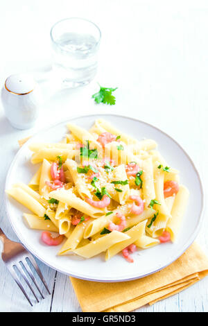 Pâtes penne aux crevettes et parmesan râpé sur fond blanc Banque D'Images