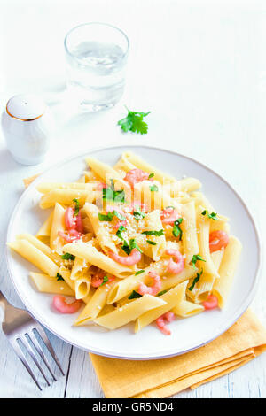 Pâtes penne aux crevettes et parmesan râpé sur fond blanc Banque D'Images