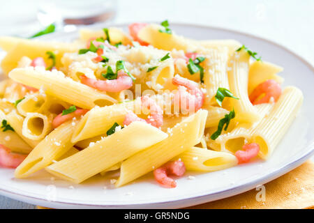 Pâtes penne aux crevettes et parmesan râpé sur fond blanc Banque D'Images