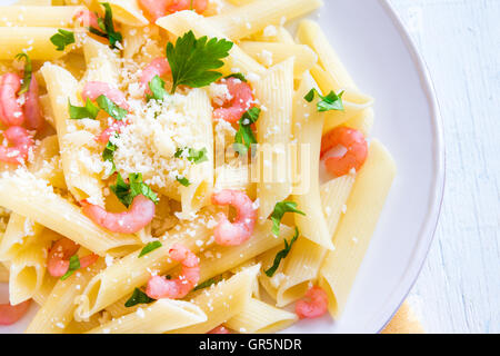 Pâtes penne aux crevettes et parmesan râpé sur fond blanc Banque D'Images