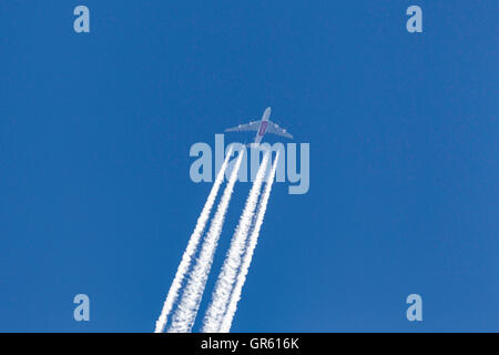 Emirates Airlines Airbus A380 avions super jumbo à haute altitude avec une longue traînée blanche streaming derrière l'avion. Banque D'Images