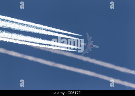 Emirates Airlines Airbus A380 avions super jumbo à haute altitude avec une longue traînée blanche streaming derrière l'avion. Banque D'Images