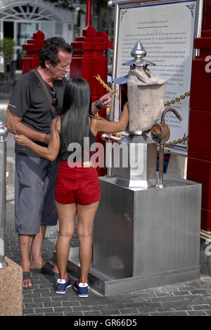 Mérite. Les gens éclairant les bâtons de Joss et rendant hommage à un monument bouddhiste thaïlandais. Thaïlande S. E. Asie Banque D'Images