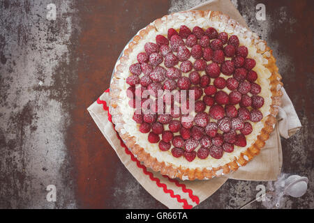 Tarte aux framboises avec crème à la vanille et le sucre glace. Macro, selective focus, tons vintage image, espace blanc Banque D'Images