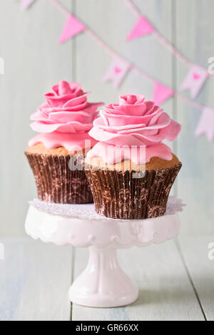 Cupcakes avec deux fleurs rose Banque D'Images