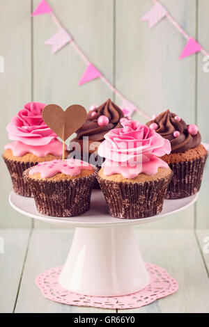 Cupcakes avec sweet rose des fleurs et une cakepick pour le texte Banque D'Images