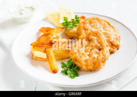 Des croquettes de poisson avec frites sur plaque blanche close up Banque D'Images