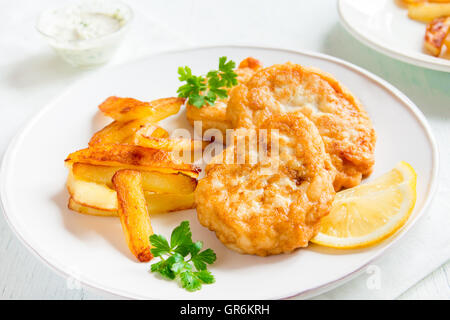 Des croquettes de poisson avec frites sur plaque blanche close up Banque D'Images