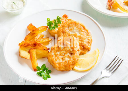 Des croquettes de poisson avec frites sur plaque blanche close up Banque D'Images