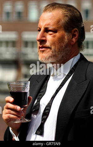 L'homme à la cigarette avec un verre de vin Banque D'Images