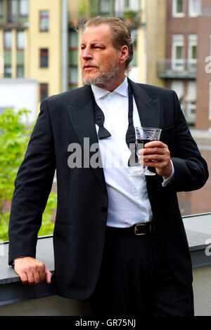 L'homme à la cigarette avec un verre de vin Banque D'Images